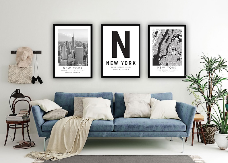 a living room with a blue sofa, a potted plant, and three framed pictures of New York City.