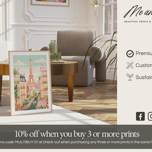The image is an advertisement for a company called "Me and Kate" that offers beautiful prints and walls. It features a framed picture of a cityscape, a sofa, and a coffee table in a living room setting. The company emphasizes the premium quality, customizability, and sustainability of their products. They also offer a 10% discount on purchases of 3 or more prints, and encourage customers to enter a promotion code "MULTIBuy10" at the checkout to receive the discount.