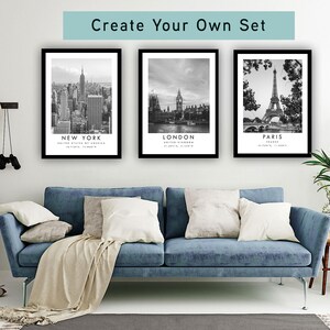a living room with a blue sofa, a potted plant, and three framed pictures of famous landmarks in New York, London, and Paris.