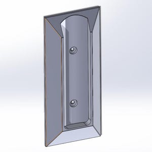 May include: A gray, rectangular object with a recessed central channel and two circular indentations. The object has a beveled edge and a geometric design, likely a component or part.