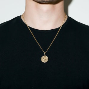 May include: A gold chain necklace with a round pendant featuring an owl design. The pendant has intricate details and the word "LOVE" inscribed around the edge.