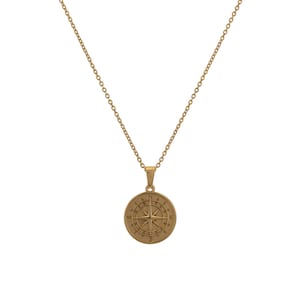 May include: Gold compass necklace with a round pendant featuring a compass rose design. The pendant has the letters N, S, E, and W around the compass rose.