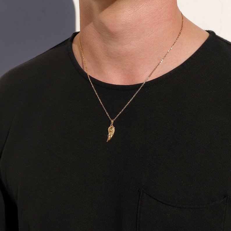 Puede incluir: Un collar de cadena de oro con un peque&ntilde;o colgante de ala de oro.