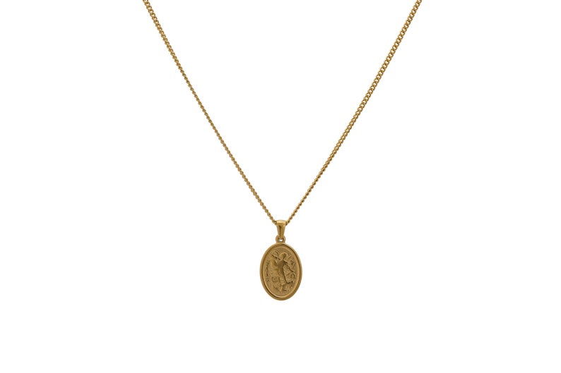 May include: A gold chain necklace with a small oval pendant featuring a detailed design.