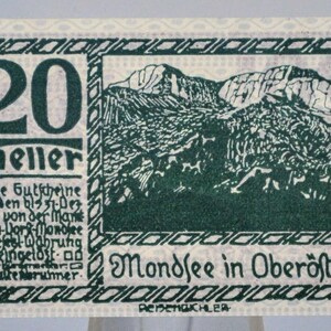 May include: A vintage postage stamp with a green and white design. The stamp features the number "20" and the word "heller" in large, bold text. A mountain landscape is depicted in the center, with text in German.