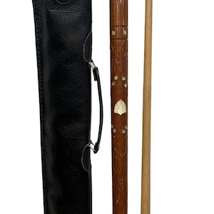 May include: A two-piece wooden pool cue with a brown finish, featuring intricate carved leaf patterns and inlaid mother-of-pearl accents. The cue includes a white ferrule, a black tip, and a black textured leather carrying case with a handle.
