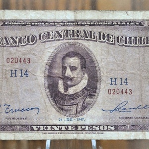 Op de afbeelding: Een vintage Chileense Peso-bankbiljet van 20 pesos met een portret van een man in een witte kraag en een bruin jasje. Het bankbiljet is gedateerd 24-XII-1947 en heeft de tekst "Banco Central de Chile" erop gedrukt.