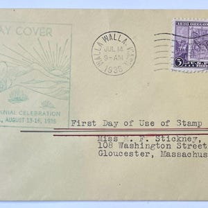 May include: A vintage cream-colored envelope featuring a green cachet of a covered wagon and the text FIRST DAY COVER, WHITMAN CENTENNIAL CELEBRATION, WALLA WALLA, WASH., AUGUST 13-16, 1936. It includes a purple 3-cent Oregon Territory postage stamp.