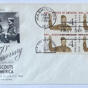 Könnte beinhalten: Ein weißer Ersttagsbrief mit einer schwarz-weißen Illustration von drei Pfadfindern, dem Text 50th Anniversary Boy Scouts of America 1910 Fifty Years of Service 1960 und vier 4c-Briefmarken mit Pfadfindergruß und Poststempel.
