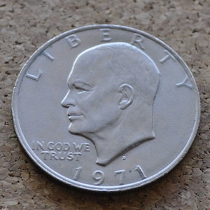 Könnte beinhalten: Silberne US-Dollar-Münze mit dem Profil von Präsident Dwight D. Eisenhower und den Worten "Liberty" und "In God We Trust". Die Münze ist mit 1971 datiert.