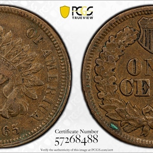 Puede incluir: Dos monedas de bronce Indian Head. Un lado presenta un perfil de un nativo americano con un tocado de plumas, el año 1865 y las palabras "UNITED STATES OF AMERICA". El otro lado muestra "ONE CENT" dentro de una corona.
