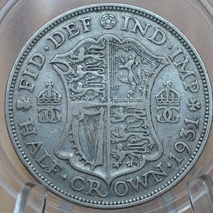 Puede incluir: Moneda de media corona de plata de 1931, con el escudo de armas real y la inscripción "FID DEF IND IMP", "HALF CROWN" y "1931".