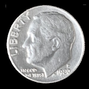 May include: A silver US dime coin with the words "LIBERTY" and "IN GOD WE TRUST" and the year "1980" inscribed on it.