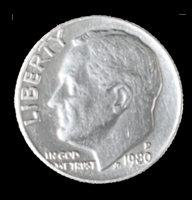 May include: A silver US dime coin with the words "LIBERTY" and "IN GOD WE TRUST" and the year "1980" inscribed on it.