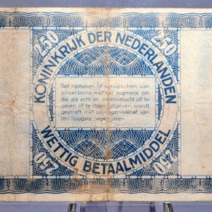 May include: An aged Dutch 250-guilder banknote. The blue and white design features intricate patterns and text, including "KONINKRIJK DER NEDERLANDEN" and "WETTIG BETAALMIDDEL". The note shows signs of wear and age.