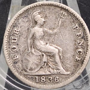 May include: An antique silver coin from 1836, featuring a seated figure holding a trident. The coin is inscribed with "FOUR PENCE" and the year. The coin is encased in a clear protective holder.