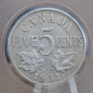 Könnte beinhalten: Eine kanadische Fünf-Cent-Münze aus Silber mit dem Jahr 1931, den Worten "CANADA FÜNF CENTS" und zwei Ahornblättern.