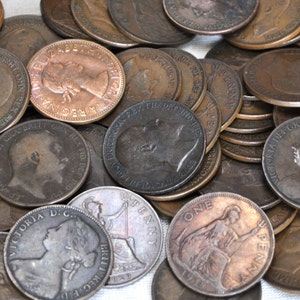 May include: A collection of vintage copper British coins, featuring various monarchs and denominations, including one penny, two pence, and half penny coins.