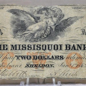 Könnte beinhalten: Antike Zwei-Dollar-Banknote der Missisquoi Bank mit Frauenporträts und einem Adler. Der Text lautet "Will pay TWO DOLLARS" und das Datum "June 1 1862".