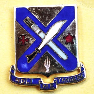 Pode incluir: Um remendo de unidade militar azul e dourado com uma cruz branca e uma estrela vermelha. O texto "101st Airborne" está na parte inferior do remendo.