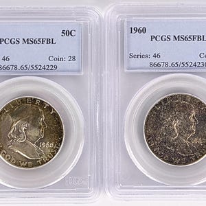Pode incluir: Duas moedas de meio dólar Franklin de 1960 encapsuladas em suportes de plástico transparente PCGS. Cada etiqueta indica 1960 50C PCGS MS65FBL Series 46 Coin 28 com os números de série 86678.65/5524229 e 86678.65/5524230.
