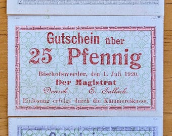 May include: Three vintage German Pfennig banknotes. The top note is green and features the text "10 Pfennig". The middle note is red and reads "25 Pfennig". The bottom note is blue and says "50 Pfennig".