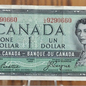 Puede incluir: Un billete de un dólar canadiense vintage, con un retrato de una mujer y el texto "CANADA ONE DOLLAR". El billete tiene un esquema de color verde y negro con el texto "BANK OF CANADA" y el número "1" en un lugar destacado.