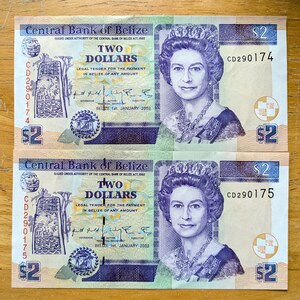 May include: Two Belize two-dollar banknotes. Each note displays a portrait of a woman adorned with a crown and jewellery. The bills feature the text "Central Bank of Belize" and "Two Dollars". Serial numbers are CD290174 and CD290175.