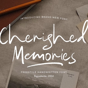 May include: A white handwritten font design on a brown fabric background. The font says "Cherished Memories" and "Freestyle Handwritten Font" with the location "Yogyakarta, 2024".