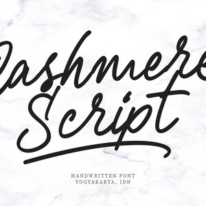 Könnte beinhalten: Schwarzes, kursives Schriftartdesign mit der Aufschrift "Cashmere Script" auf weißem Marmorhintergrund. Darunter steht "HANDWRITTEN FONT" und "YOGYAKARTA, IDN". Die Schriftart hat ein stilvolles, elegantes Aussehen.