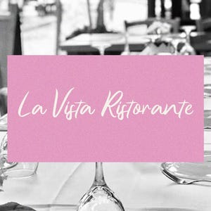 May include: A pink sign with white text that reads "La Vista Ristorante" on a table set with white linens and silverware in a restaurant.