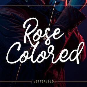 May include: A person wearing a dark jacket with the text "Rose Colored" in white cursive lettering. The text is centred on the image and is the main focus of the image. The background is a dark blue.