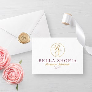 May include: A white card with a gold circle containing the letters "B" and "S" in a cursive font. The text "BELLA SHOPIA Premium Wardrobe" is below the circle in a burgundy font.