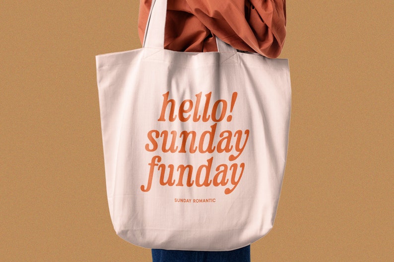 May include: A white tote bag with orange text that reads "hello! sunday funday" and "SUNDAY ROMANTIC" in a smaller font.