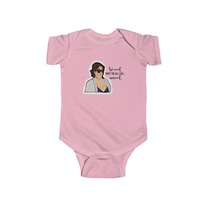 Può includere: Body rosa per neonato con un'illustrazione di cartone animato di una donna con occhiali da sole e un accappatoio bianco. Il testo "be cool don't be all like... uncool" è stampato sul body.