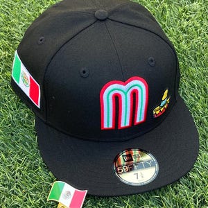 May include: Black baseball cap with a flat brim, featuring a large "M" in red, green, and white, and a Mexican flag patch. A small pin of the Mexican flag is also present. The cap has a "59FIFTY" sticker.