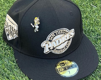 Pode incluir: Um boné de beisebol preto dos Padres de San Diego com aba reta. O boné apresenta o logotipo da equipe, um patch que diz "All-Star Game" e um pequeno alfinete de jogador de beisebol. O chapéu é um estilo 59FIFTY.