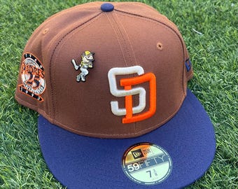 Se incluye un pin nuevo y original para la gorra ajustada de los Padres de San Diego.