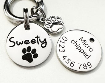 May include: Two silver dog tags with a paw print charm. The first tag says "Sweetie" with a paw print. The second tag says "Micro chipped" with the numbers 0123 456 789.