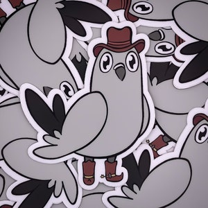 Op de afbeelding: Een set grijze en witte cartoon-vogel stickers met rode cowboyhoeden en laarzen. De vogels dragen cowboyhoeden en laarzen en hebben grote ogen. De stickers zijn perfect om een vleugje whimsy toe te voegen aan elk project.