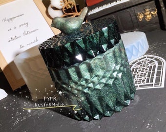 Può includere: Scatola in resina verde scuro sfaccettata con coperchio a forma di uccello. La scatola ha un design geometrico e una finitura glitterata. Il testo "FYFM Resin & Molds" è visibile. Sullo sfondo c'è una citazione incorniciata.