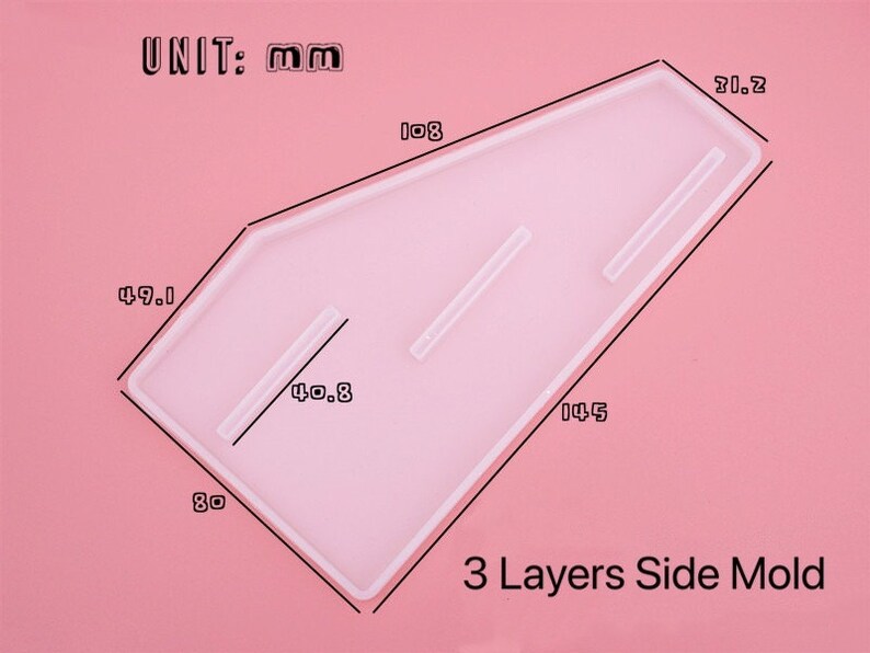 Pode incluir: Um molde de silicone transparente para criar pe&ccedil;as laterais de tr&ecirc;s camadas. O molde tem a forma de um trap&eacute;zio com cantos arredondados e mede 14,5 cm por 8 cm por 4,9 cm. O molde tem tr&ecirc;s canais para criar camadas. UNIT: mm