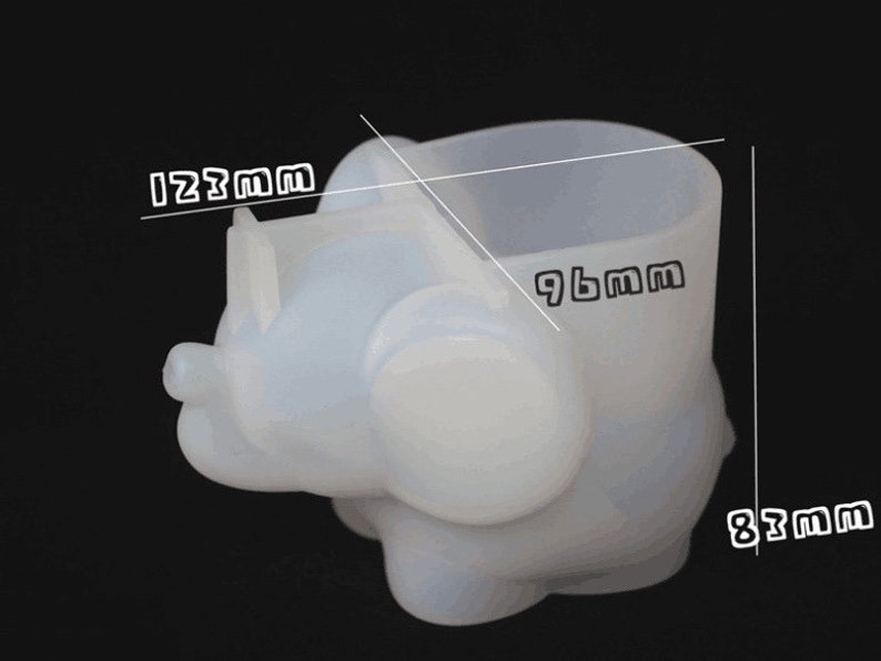 Puede incluir: Maceta de silicona blanca con forma de elefante con una maceta de 24,4 cm de alto. La maceta tiene 21,1 cm de ancho y 31,2 cm de largo.