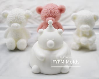 May include: Three white teddy bear shaped silicone molds, one with a crown on its head, and one pink teddy bear shaped silicone mold. The molds are on a white surface. The text "Do It Yourself - FYFM Molds" is on the surface.