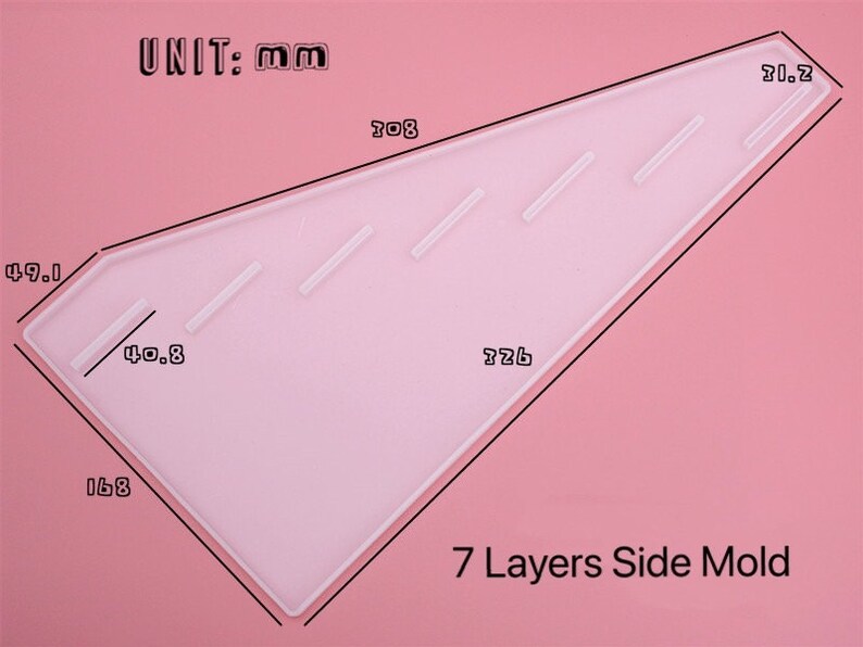 Pode incluir: Um molde de pl&aacute;stico transparente para fazer 7 camadas de bolo. O molde tem a forma de um tri&acirc;ngulo com medidas em mil&iacute;metros. O texto "UNIT: mm" e "7 Layers Side Mold" est&aacute; impresso no molde.
