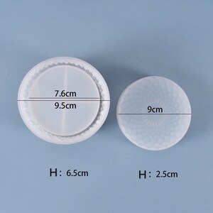 May include: Two clear silicone molds for crafting. One is a round coaster mold, 3.7 inches in diameter and 2.6 inches high, with a textured edge. The other is a smaller round mold, 3.5 inches in diameter and 1 inch high, with a floral design.