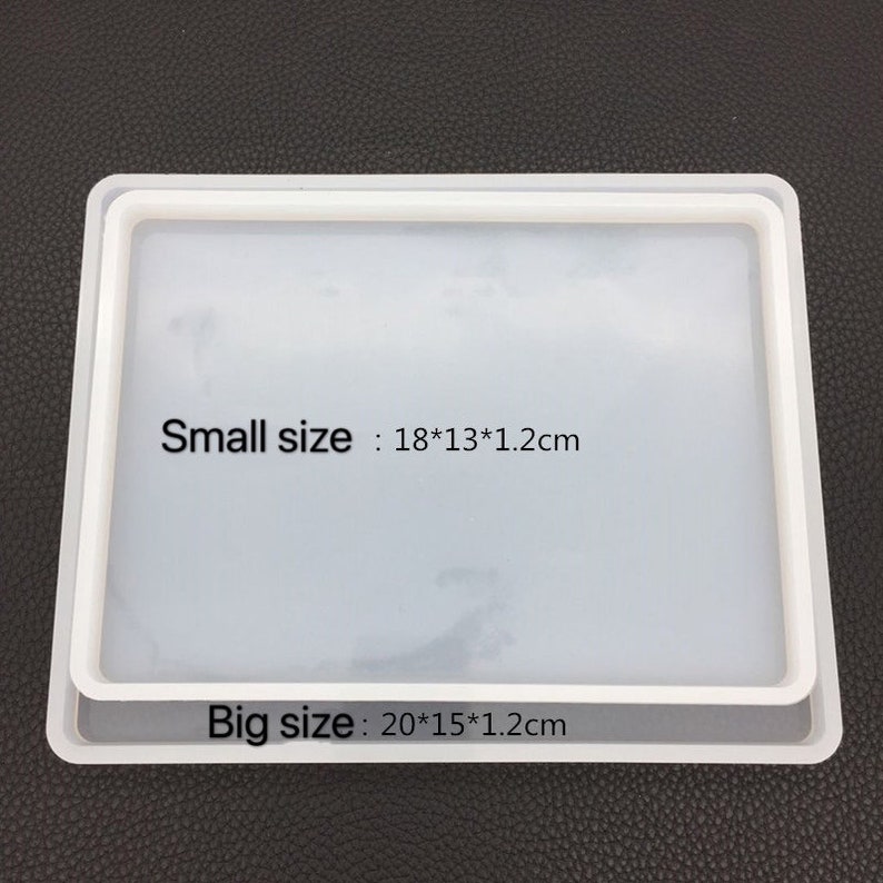 May include: Two white rectangular silicone molds, one slightly smaller than the other, are stacked. The smaller mold is 7.1 x 5.1 x 0.5 inches, and the larger mold is 7.9 x 5.9 x 0.5 inches. Text on the image indicates the sizes.