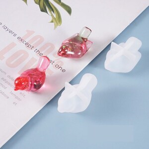 Peut inclure: Deux moules en silicone transparents en forme d'oiseaux et deux figurines d'oiseaux en résine rose. Les moules en silicone sont sur une surface blanche, et les figurines en résine sont sur une surface blanche avec du texte.