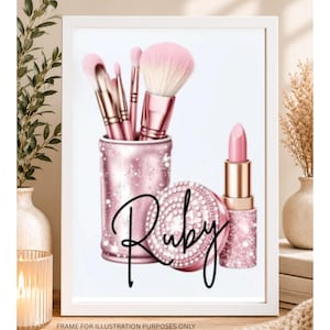 May include: A framed print featuring a pink glittery makeup brush holder containing several makeup brushes, a pink glittery compact, and a pink lipstick tube. The word Ruby is written in black cursive script across the center of the image.