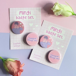 Puede incluir: Dos juegos de insignias rosas y moradas con una imagen de dibujos animados de una persona con gafas y el texto "Mingi badge set" y "Certified Mingi stan".